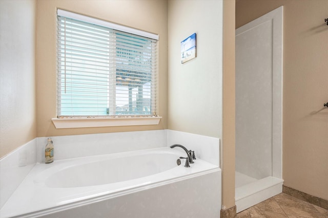 full bathroom featuring a stall shower, a bath, and tile patterned floors