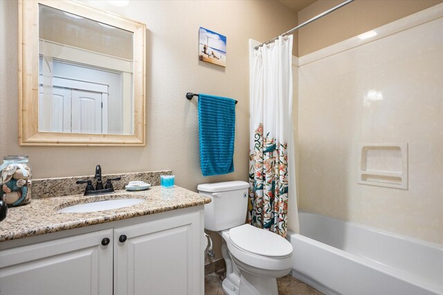 full bathroom with vanity, shower / bath combo with shower curtain, and toilet