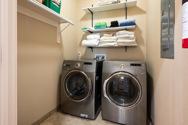 laundry area with laundry area, light tile patterned floors, baseboards, and washing machine and clothes dryer