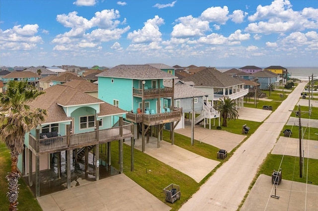 exterior space featuring a carport, driveway, a residential view, and a balcony