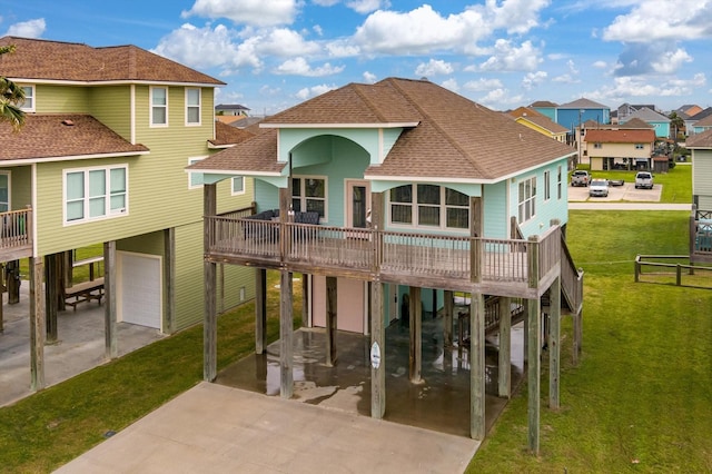 rear view of house with a carport, a garage, a yard, and a balcony