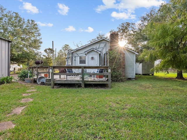 rear view of house with a wooden deck and a lawn