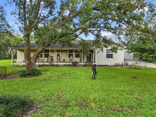 rear view of property featuring a yard and covered porch