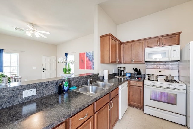 kitchen with sink, white appliances, light tile patterned floors, ceiling fan, and tasteful backsplash