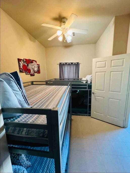 bedroom featuring light tile patterned floors and ceiling fan