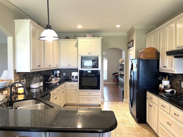 kitchen with pendant lighting, sink, ornamental molding, black appliances, and decorative backsplash