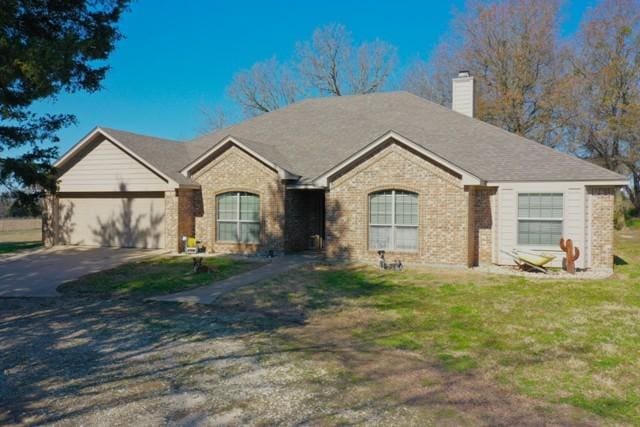 ranch-style home featuring a garage and a front lawn