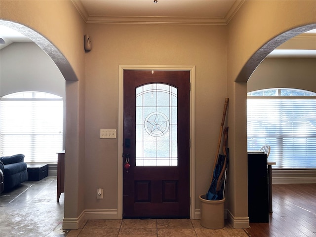 entrance foyer featuring crown molding and plenty of natural light