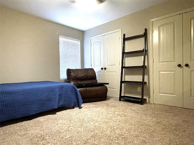 carpeted bedroom with two closets and ceiling fan