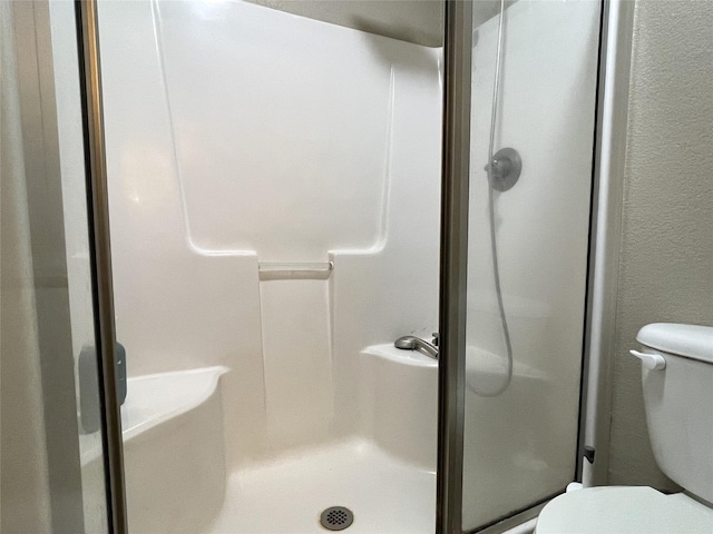 bathroom featuring a shower and toilet