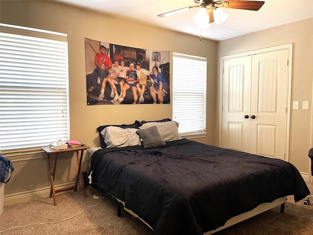 carpeted bedroom with ceiling fan and a closet