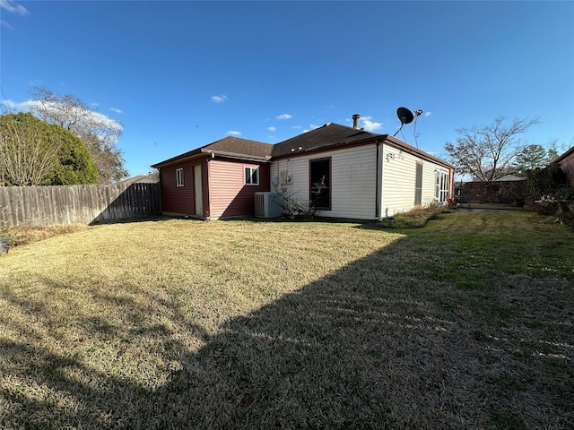 rear view of property with a yard and central AC unit