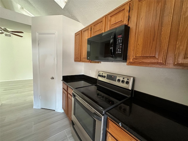 kitchen with stainless steel electric range oven, light wood-type flooring, a textured ceiling, and ceiling fan