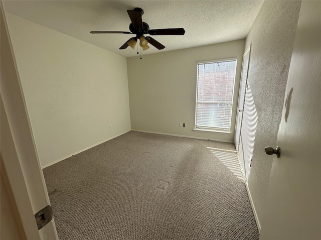 carpeted spare room featuring ceiling fan and a textured ceiling