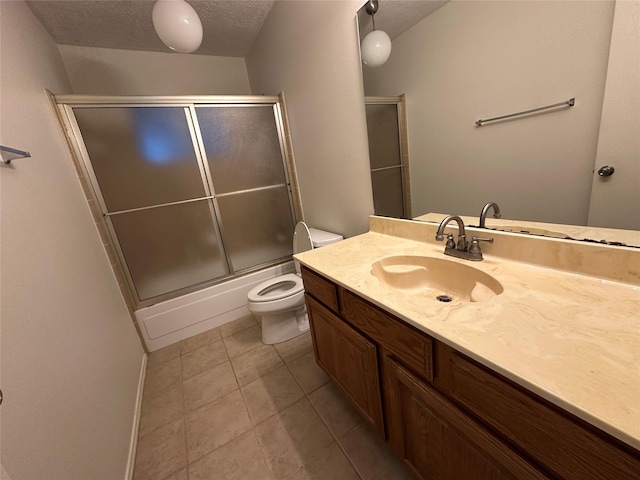 full bathroom with shower / bath combination with glass door, tile patterned flooring, vanity, toilet, and a textured ceiling