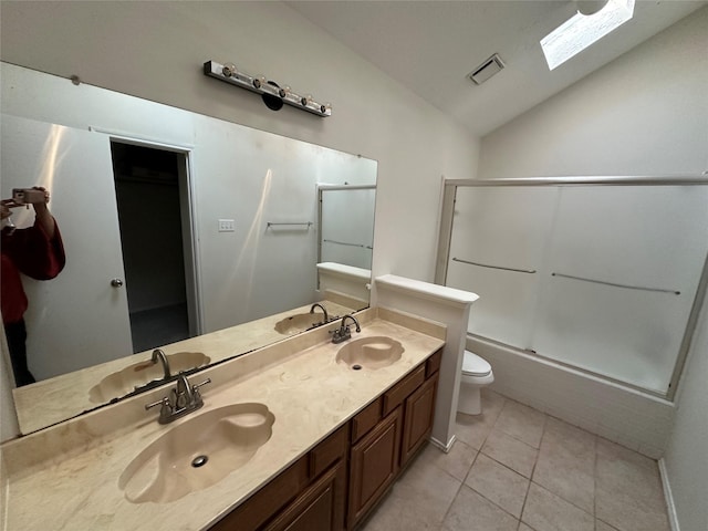 full bathroom featuring combined bath / shower with glass door, vaulted ceiling with skylight, vanity, tile patterned floors, and toilet