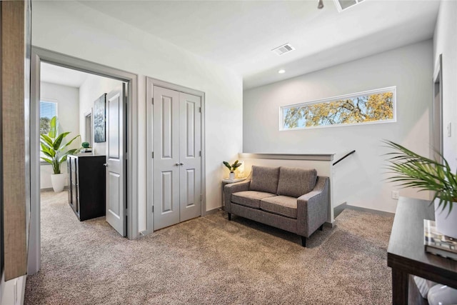 sitting room with carpet floors and a wealth of natural light