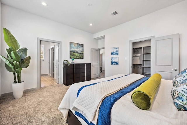 carpeted bedroom featuring a spacious closet, ensuite bath, and a closet