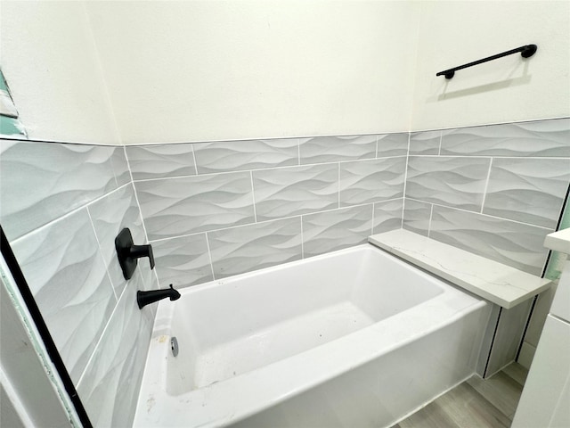 bathroom featuring a bathtub and tile walls