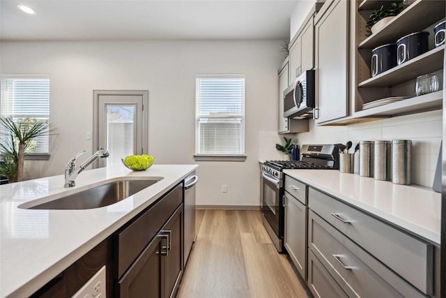 kitchen featuring stainless steel appliances, sink, a wealth of natural light, and light hardwood / wood-style floors