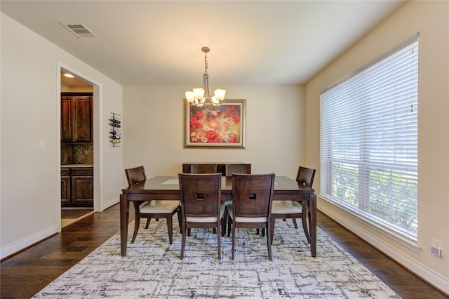 dining area featuring hardwood / wood-style flooring and a chandelier