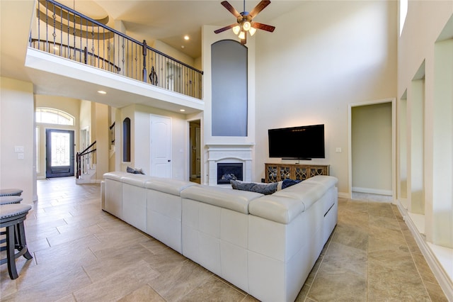 living room with ceiling fan and a towering ceiling