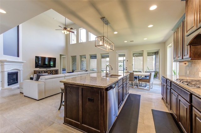 kitchen featuring sink, appliances with stainless steel finishes, an island with sink, pendant lighting, and a healthy amount of sunlight