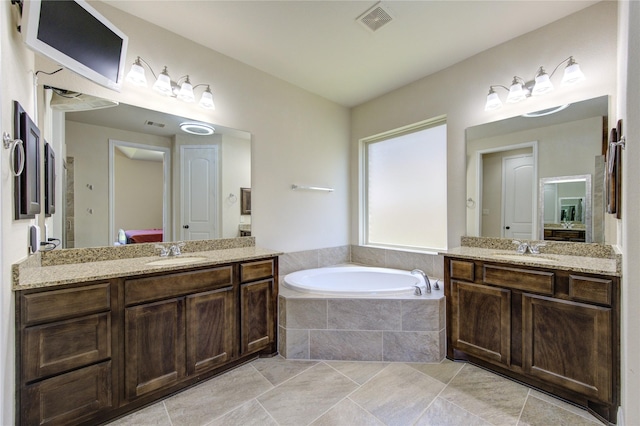 bathroom with vanity, tiled bath, and tile patterned floors