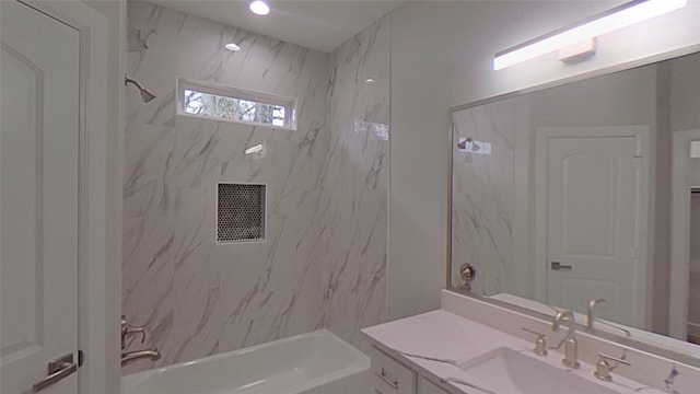 bathroom featuring tiled shower / bath and vanity