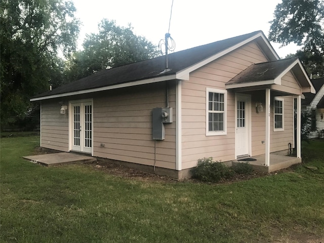 back of property with french doors and a yard