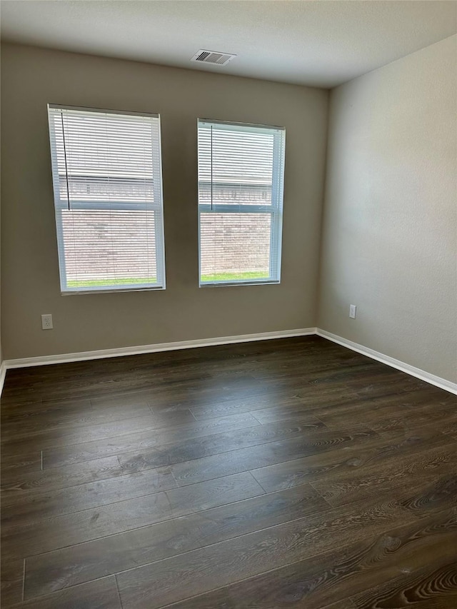 unfurnished room featuring dark hardwood / wood-style floors and a wealth of natural light