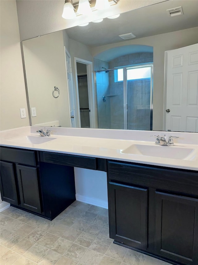 bathroom featuring a shower with door and vanity