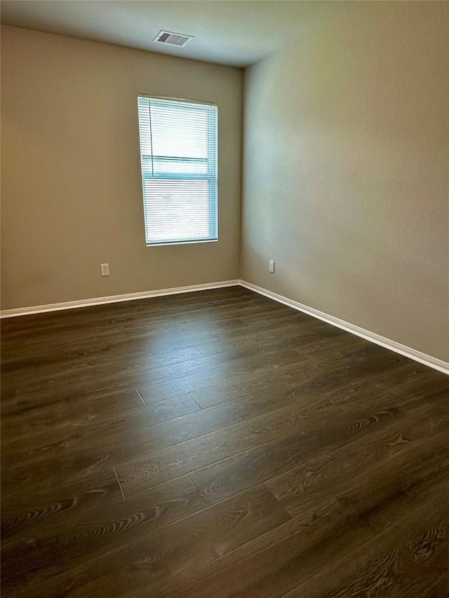 spare room with dark wood-type flooring