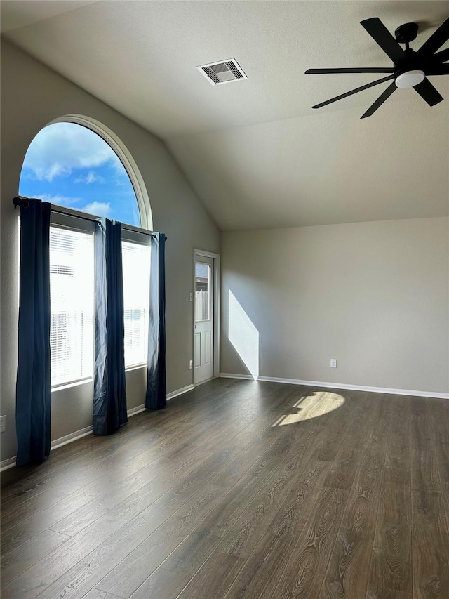 empty room with ceiling fan, lofted ceiling, and dark hardwood / wood-style flooring