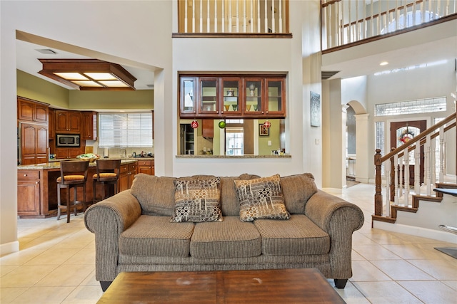 tiled living room featuring a towering ceiling