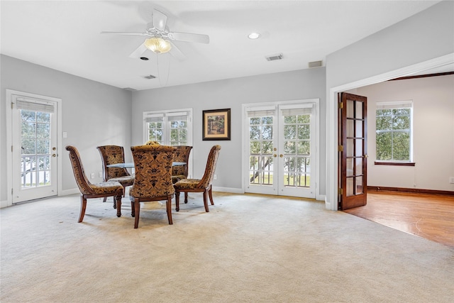 carpeted dining area with a wealth of natural light, ceiling fan, and french doors