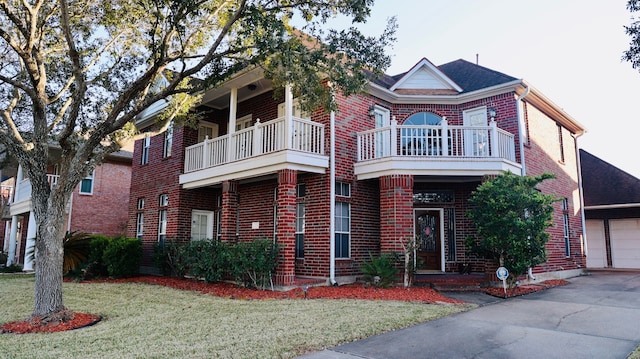 view of front of home featuring a balcony, a garage, and a front yard