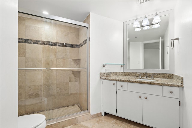 bathroom with vanity, toilet, an enclosed shower, and tile patterned flooring