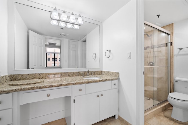 bathroom with vanity, toilet, a shower with shower door, and tile patterned flooring