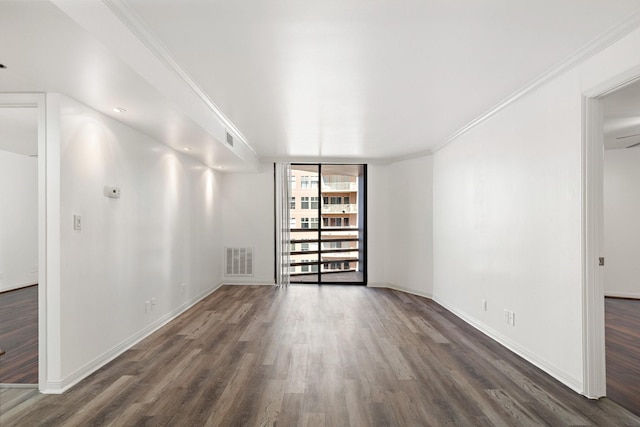 empty room featuring crown molding, floor to ceiling windows, and dark hardwood / wood-style flooring