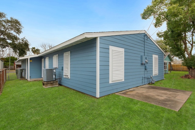 back of house featuring central AC, a patio area, and a lawn