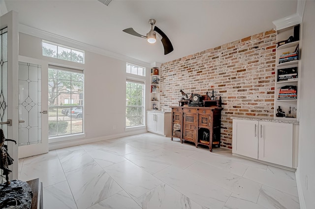 unfurnished living room with crown molding, brick wall, and ceiling fan