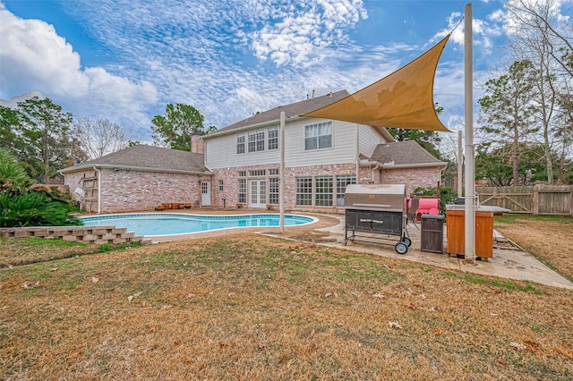 view of swimming pool with a yard, a jacuzzi, and grilling area