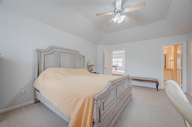 carpeted bedroom featuring ceiling fan, ensuite bath, a raised ceiling, and vaulted ceiling