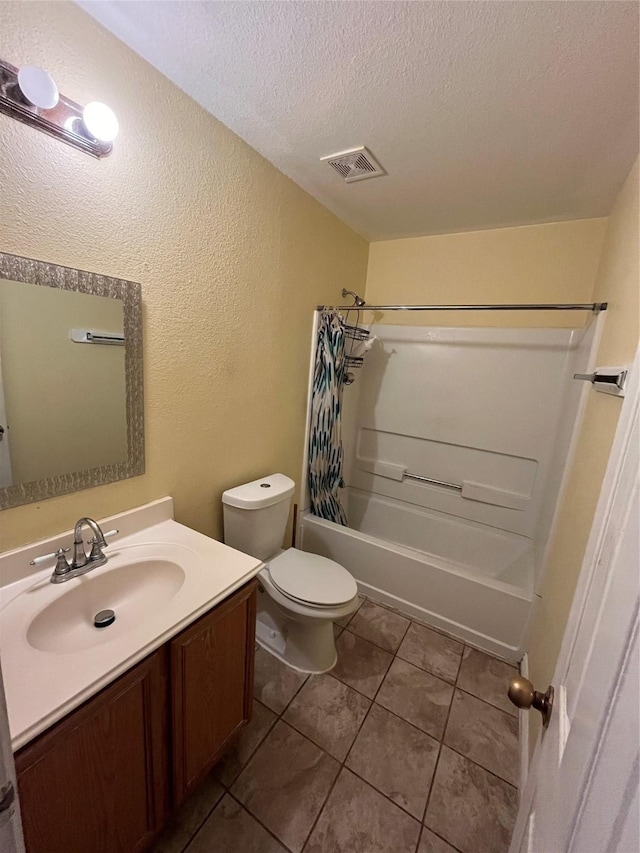 full bathroom featuring shower / tub combo, vanity, a textured ceiling, tile patterned floors, and toilet