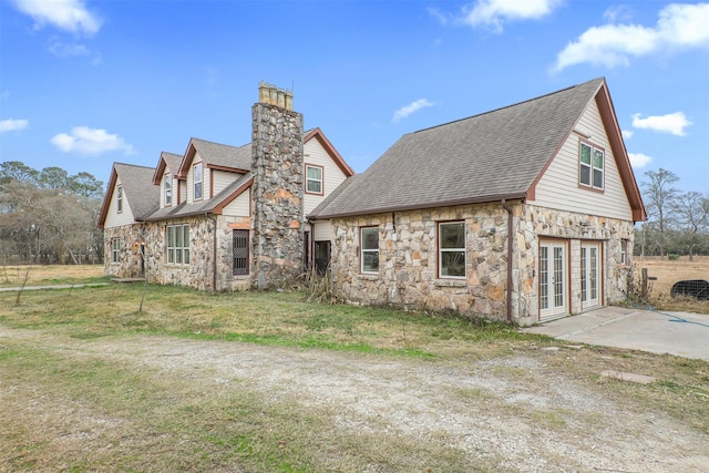 view of home's exterior featuring a yard and french doors