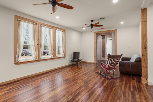 living area featuring dark wood-type flooring and ceiling fan