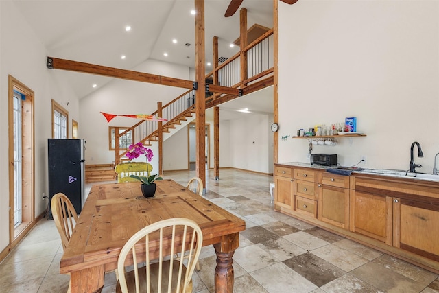 dining area featuring sink and high vaulted ceiling