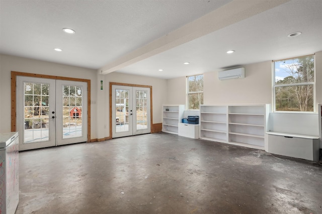 interior space with concrete floors, a wall unit AC, and french doors