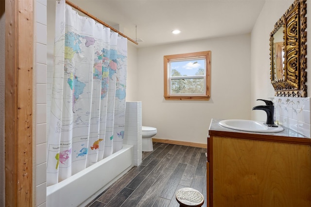 full bathroom featuring vanity, hardwood / wood-style floors, shower / bath combination with curtain, and toilet